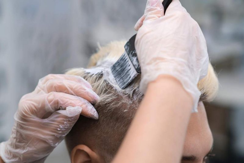 hair-dyeing-for-young-man-in-hairdressing-salon-the-master-bleaches-the-hair-of-the-client