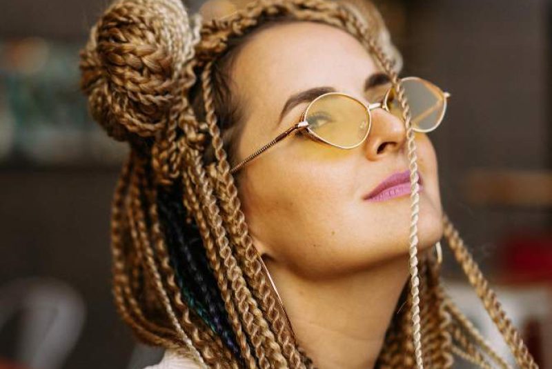 young-beautiful-multiracial-woman-with-blonde-afro-hairstyle-braids-zizi-on-the-street-cafe-yellow-sunglasses-bright-makeup-hippie-style